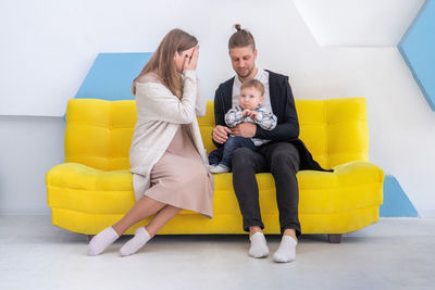 Young woman using laptop while sitting on sofa at home