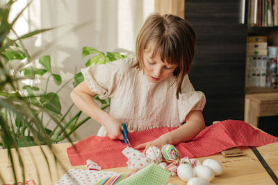 Side view of girl sitting on table