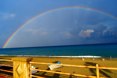 Scenic view of rainbow over sea against sky