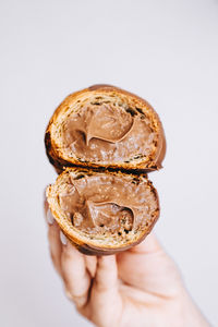Close-up of hand holding ice cream over white background