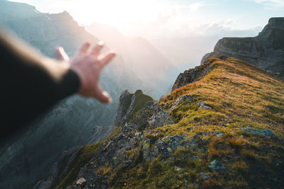 Cropped hand of man in front of rock