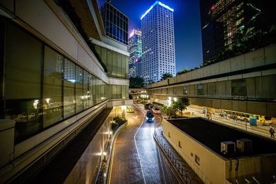 Cars on road amidst modern buildings in city at night