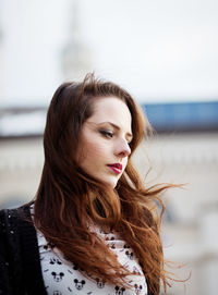 Portrait of beautiful young woman standing outdoors on the wind