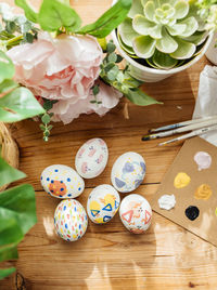 Top view of modern easter eggs painted. brushes and paints with flowers and plants. happy easter 