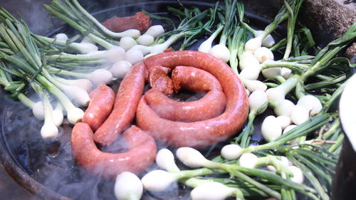 High angle view of fresh vegetables and meat being cooked in a grill