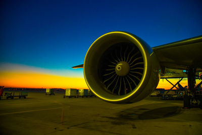 Airplane on airport runway against clear blue sky