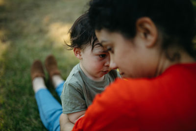 Close-up of mother and son sitting outdoors