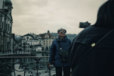 Man standing in city against sky