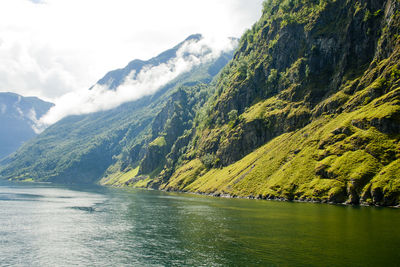 Scenic view of lake by mountains against sky