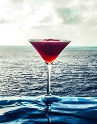 Close-up of red wine in sea against sky