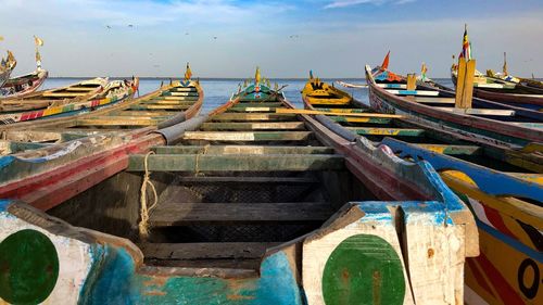 Panoramic view of boats moored at beach against sky