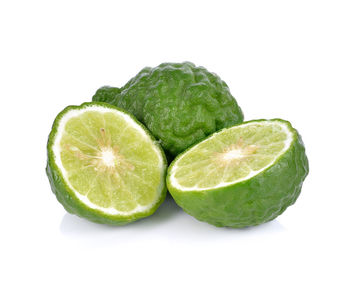 Close-up of green fruit against white background