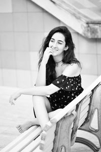 Portrait of smiling young woman sitting outdoors