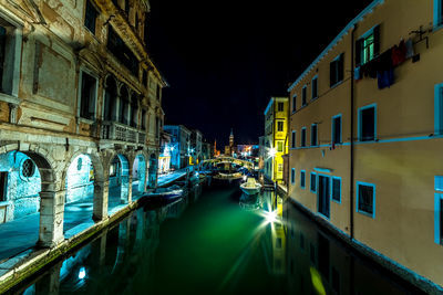 Canal passing through city at night