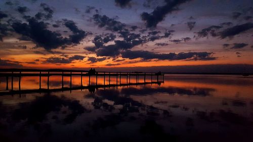 Scenic view of sea against dramatic sky during sunset