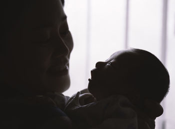 Close-up of woman carrying newborn son at home