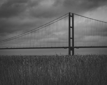 View of suspension bridge against cloudy sky