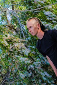 Tilt shot of young man by plants