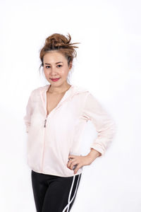 Portrait of a smiling young woman against white background