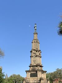 Low angle view of statue against blue sky