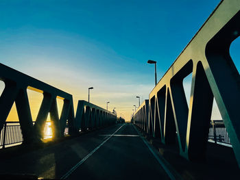 Bridge over road against sky during sunset