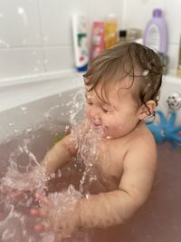 Full length of shirtless boy in bathroom at home