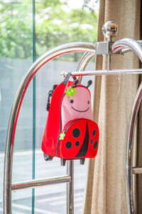 Close-up of red bicycle against window