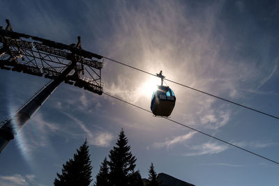 Low angle view of overhead cable car against sky