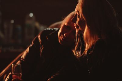 Smiling friends sitting outdoors at night