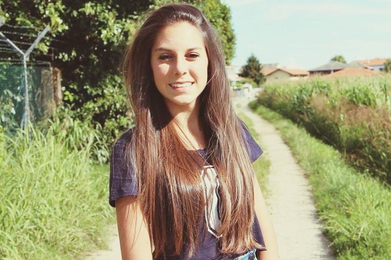 young adult, young women, long hair, portrait, looking at camera, person, lifestyles, grass, front view, casual clothing, standing, leisure activity, tree, smiling, brown hair, field, plant