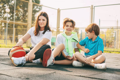 Portrait of teenagers sitting on a basketball court. children relax 