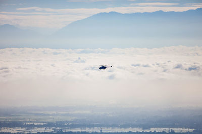 Airplane flying over mountains against sky