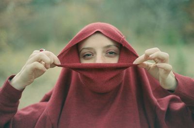 Portrait of young woman wearing hood outdoors
