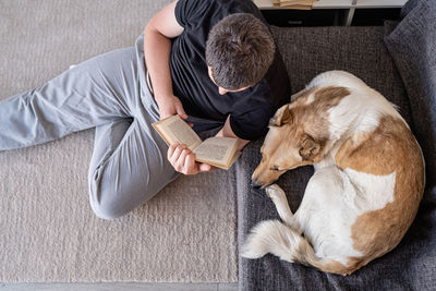 High angle view of man lying on sofa