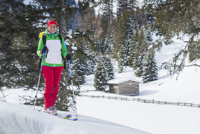 Portrait of woman skiing on snow covered land