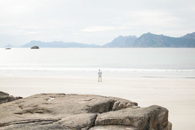 Man standing on rock at seaside