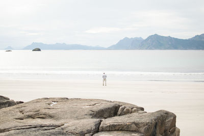 Rear view of man standing at beach