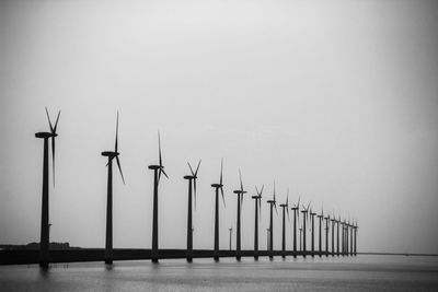 Wind turbines in row against sky