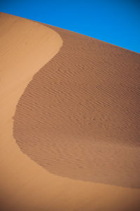 Sand dunes against clear sky