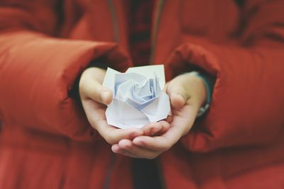 Midsection of person holding paper flower