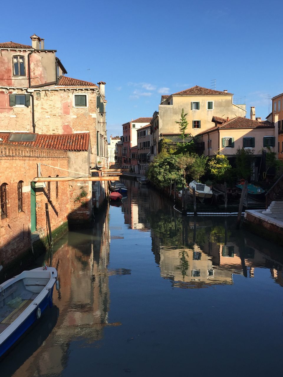 building exterior, architecture, built structure, water, canal, nautical vessel, transportation, boat, moored, clear sky, waterfront, mode of transport, residential structure, residential building, house, river, city, building, reflection, town