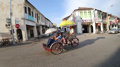 Bicycles on motorcycle against sky in city