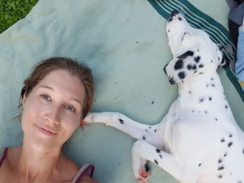 High angle portrait of woman with dog sleeping on field