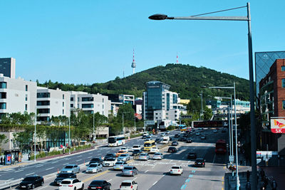 Traffic on road in city against clear sky