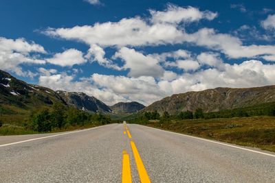 Surface level of empty road against cloudy sky