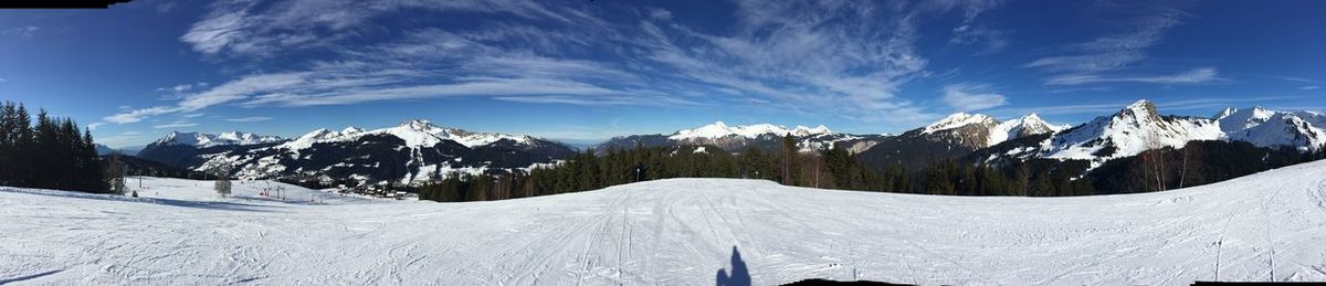 Panoramic view of snow covered mountains against sky