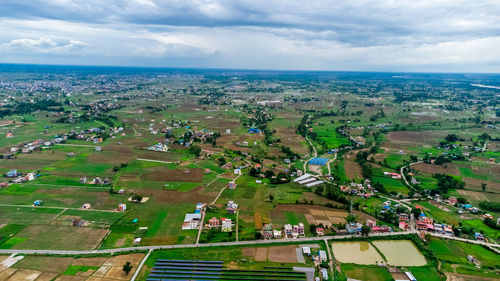 High angle view of buildings in field against sky