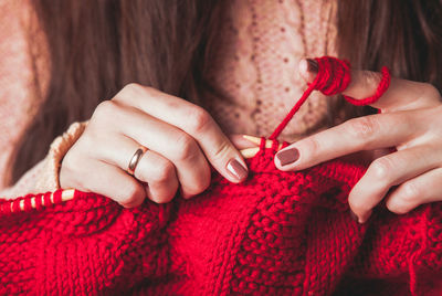 Midsection of woman knitting wool