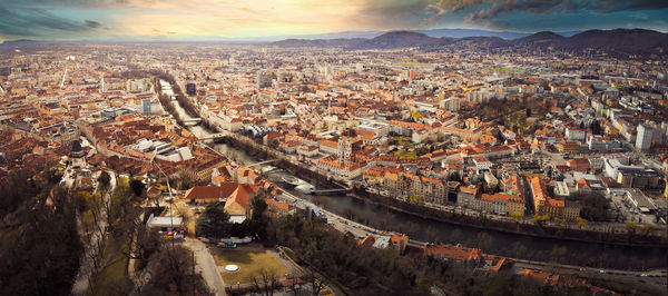 Aerial panorama view from graz hill schlossberg in austria, cityscape with house roofs, mur river 