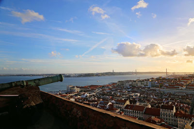 High angle view of city by sea against sky